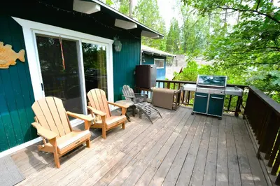 a deck with two chairs and a grill on a house at Johnson Lake FrontReduced Nightly Rates in Bass Lake