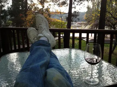 a person sitting at a table with a glass of wine at Johnson Lake FrontReduced Nightly Rates in Bass Lake