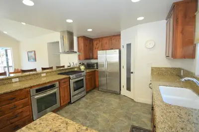 a kitchen with wooden cabinets and stainless steel appliances at Lake Shore Lake Front Free Night Special in Bass Lake