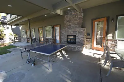 a ping pong table on a patio with a fireplace at Lake Shore Lake Front Free Night Special in Bass Lake
