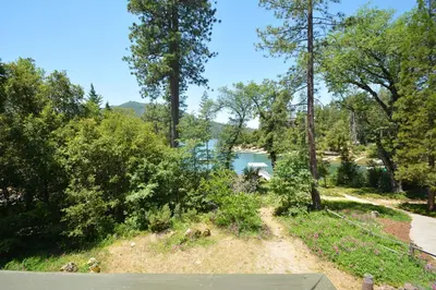 a view of a river from a hill with trees at Lake Shore Lake Front Free Night Special in Bass Lake