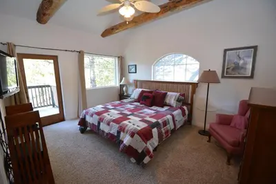 a bedroom with a bed and a red chair at Lake Shore Lake Front Free Night Special in Bass Lake