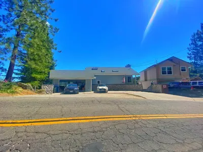 a house with two cars parked in a driveway at Beautiful Lakefront Home Spectacular View - Herrera in Bass Lake