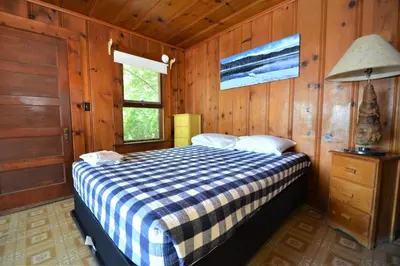 a bedroom with a bed in a wooden room at Dupzyk Lake Front Reduced Nightly Rate in Bass Lake