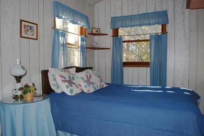 a bedroom with a blue bed and a window at Idylwild-Lake Area in Bass Lake
