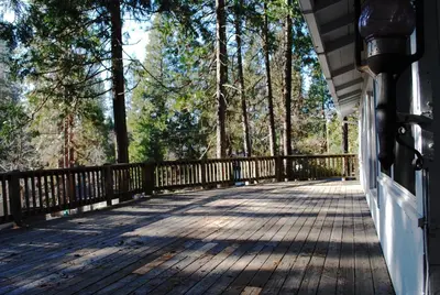 a boardwalk on a house with trees in the background at Idylwild-Lake Area in Bass Lake