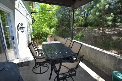 a patio with a table and chairs on a porch at King- Lake Area in Bass Lake