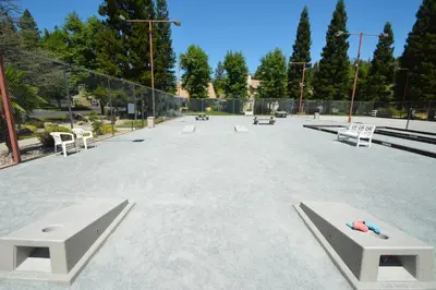 a park with benches and tables and a fence at King- Lake Area in Bass Lake