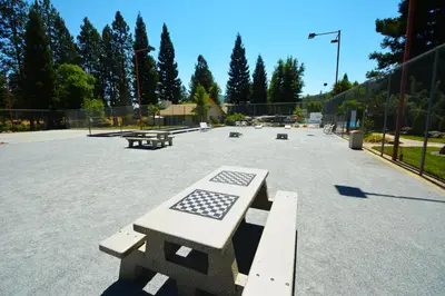 a park with benches and picnic tables in a parking lot at Walter- Lake AreaFree Night Special in Bass Lake