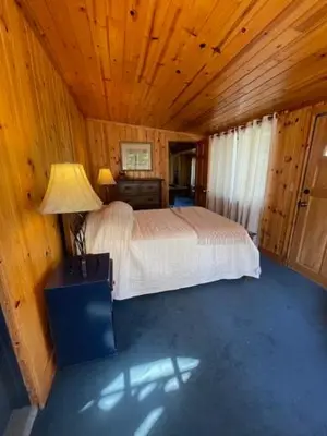 a bedroom with a bed in a wooden room at O'Connell-Lake Area Free Night Special in Bass Lake
