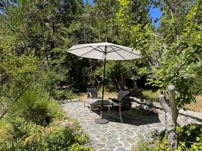 a patio with an umbrella and two chairs and a bench at O'Connell-Lake Area Free Night Special in Bass Lake