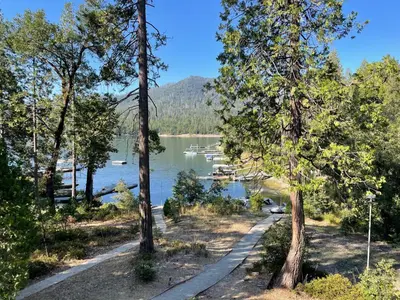 a path next to a lake with trees at Werner Lake Front in Bass Lake