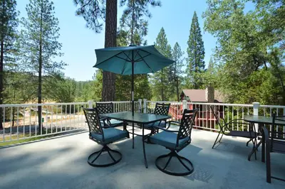 a table with chairs and an umbrella on a patio at O'Hara Lake View in Bass Lake