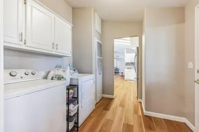a kitchen with white cabinets and a wooden floor at Newly Renovated Retreat on 6 Acres, Discover Murphys Lodge with Scenic Views! in Murphys