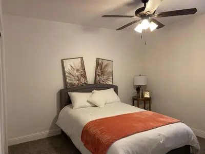 a bedroom with a bed with a ceiling fan at Entire cozy home in Madera