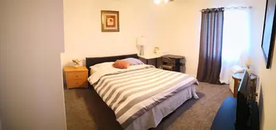 a bedroom with a bed and a desk and a window at Entire cozy home in Madera