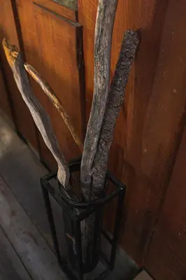a black vase with some branches in it at Sequoia Glen in Wilsonia