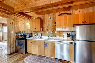 a kitchen with wooden cabinets and a stainless steel refrigerator at Pine Knolls in Tahoma
