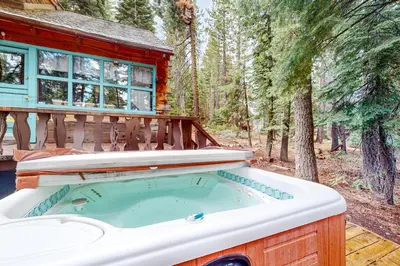 a hot tub in front of a log cabin at Pine Knolls in Tahoma