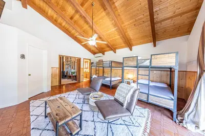 a living room with bunk beds and a table at Yosemite Cowboy Cabin in Oakhurst