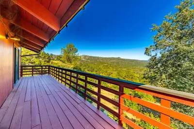 a wooden deck with a view of the mountains at Yosemite Cowboy Cabin in Oakhurst