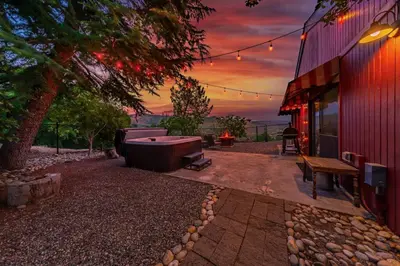 a backyard with a hot tub and a bench next to a building at Yosemite Cowboy Cabin in Oakhurst