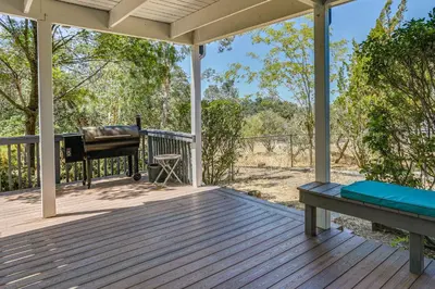 a porch with a bench and a grill on it at Pet-Friendly Coarsegold Vacation Rental with Deck! in Coarsegold
