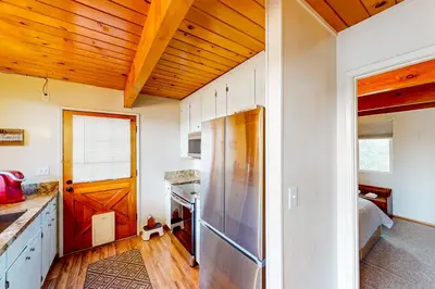 a kitchen with a refrigerator and wooden ceilings at Cozy Cabin in Groveland