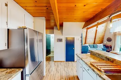 a kitchen with white cabinets and a wooden ceiling at Cozy Cabin in Groveland