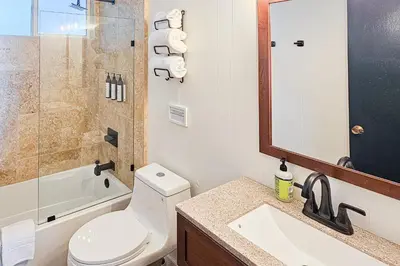 a bathroom with a toilet and a sink and a mirror at Cozy Cabin in Groveland