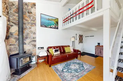 a living room with a stone fireplace and a couch at Sunrise Serenity at Tahoe Village in Stateline