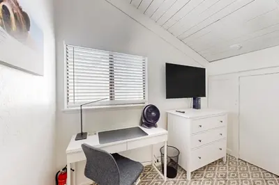 a bedroom with a desk and a tv and a window at Sunrise Serenity at Tahoe Village in Stateline