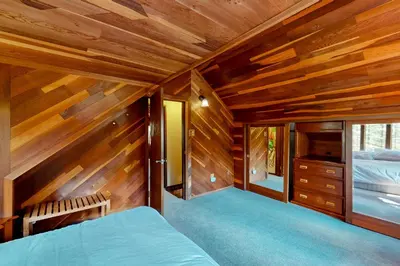 a bedroom with wooden walls and a bed and a window at Sierra Secret in Soda Springs