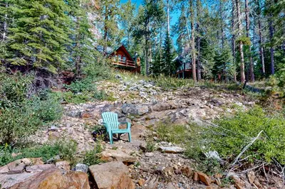 a green chair sitting in the middle of a forest at Sierra Secret in Soda Springs