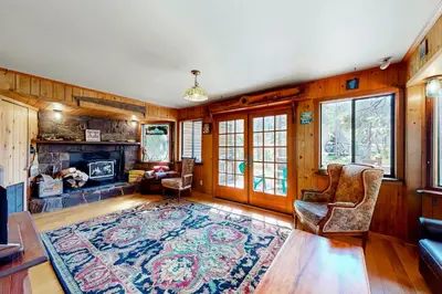 a living room with a fireplace and wooden walls at Sierra Secret in Soda Springs