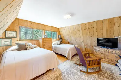 a bedroom with two beds and a flat screen tv at Fernwood in Shaver Lake
