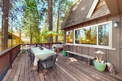 a wooden deck with a table and chairs on it at Fernwood in Shaver Lake