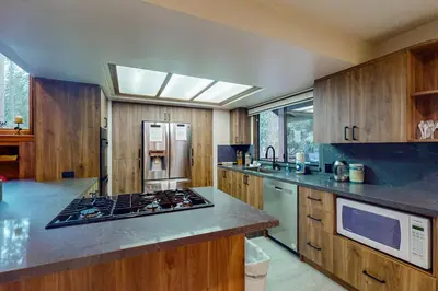 a kitchen with a stove top oven next to a refrigerator at Tranquil Pines Estate in Shaver Lake