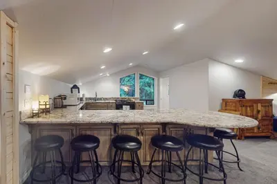 a kitchen with a large island with bar stools at Tranquil Pines Estate in Shaver Lake