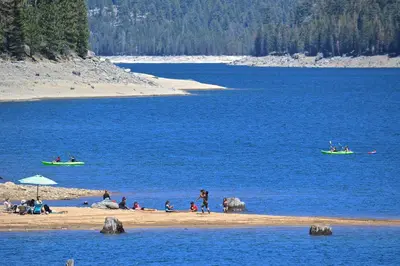 a group of people on a beach near the water at Tranquil Pines Estate in Shaver Lake