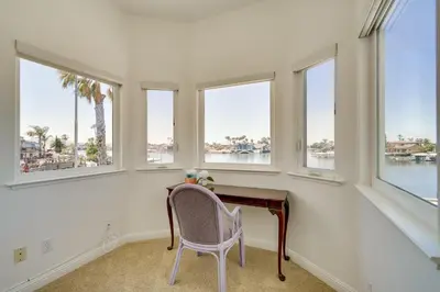 a desk with a chair in a room with windows at Discovery Bay Home with On-Site Delta Access! in Discovery Bay