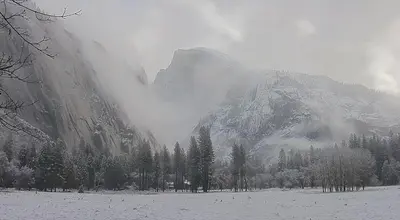 a snow covered mountain with trees in front of it at Ponderosa Creekside Retreat in Mariposa