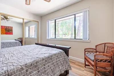 a bedroom with a bed and two chairs and a window at Ponderosa Creekside Retreat in Mariposa