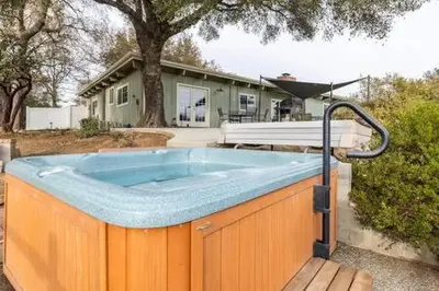 a hot tub in front of a house at Black Bear Haven Hot tub Pool table BBQ Darts in Oakhurst