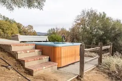 a hot tub and stairs with a fence at Black Bear Haven Hot tub Pool table BBQ Darts in Oakhurst