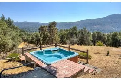 a swimming pool in the middle of a field at Black Bear Haven Hot tub Pool table BBQ Darts in Oakhurst