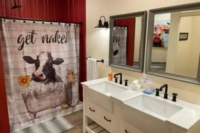 a bathroom with two sinks and a cow shower curtain at Crazy Cow Private HOT TUB BBQ Sleeps 2 in Ahwahnee