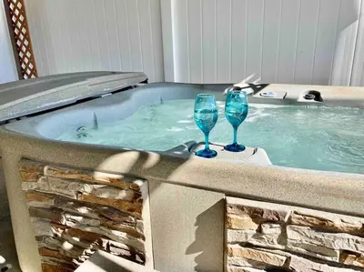 two wine glasses sitting in a hot tub at Crane Suite Hot Tub Bbq King Bed- Sleeps 4 in Ahwahnee