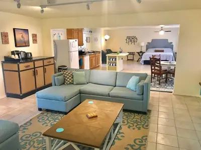 a living room with a blue couch and a kitchen at Crane Suite Hot Tub Bbq King Bed- Sleeps 4 in Ahwahnee