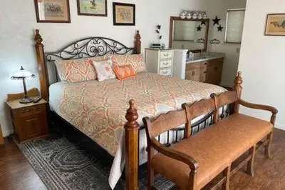 a bedroom with a bed and a table and a mirror at Creekside Dream Game Room Sleeps 12 bbq near town in Oakhurst